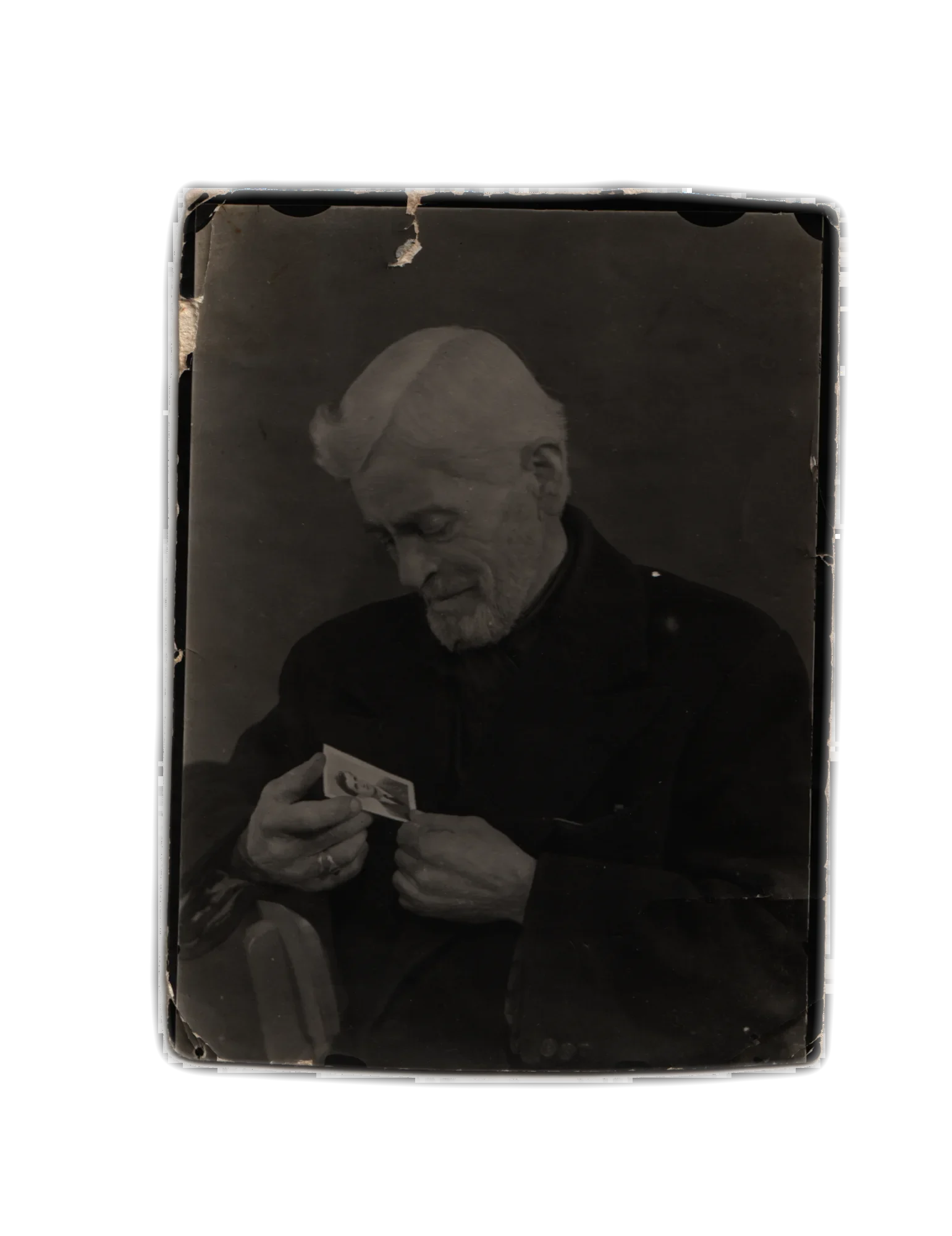 Bărbat în vârstă ținând între degete o fotografie mică de portret